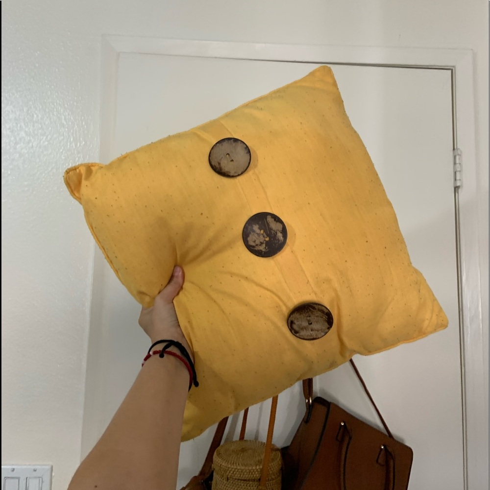 Mustard yellow decorative pillow with wooden buttons